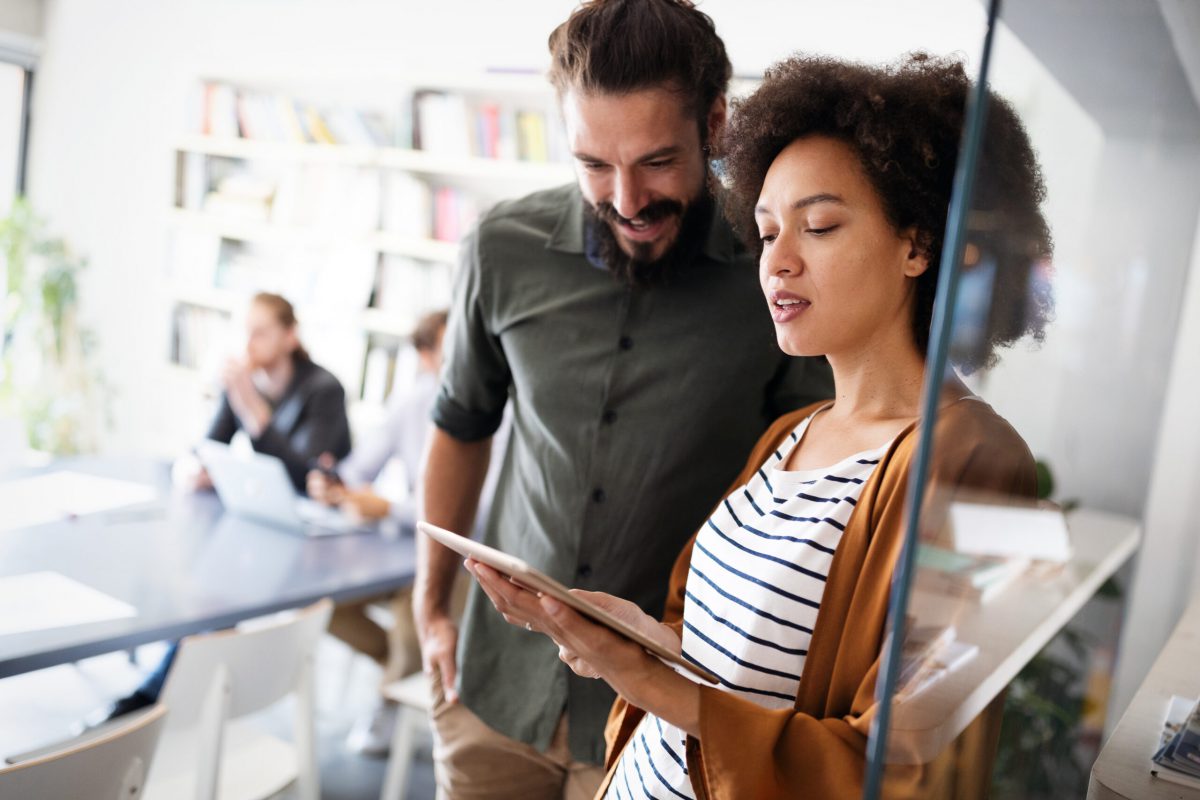 a woman explaining something on a tablet to a man
